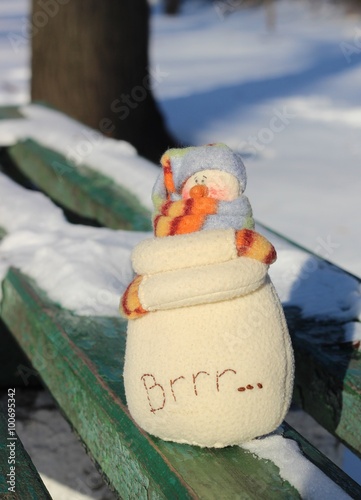 Textile handmade homemade fabric doll toy snowman in blue hat and orange stripped scarf with inscriptions 