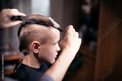 Young man is using Hairdresser making haircut to young man at beauty parlour. Fashion male model behind the scene.