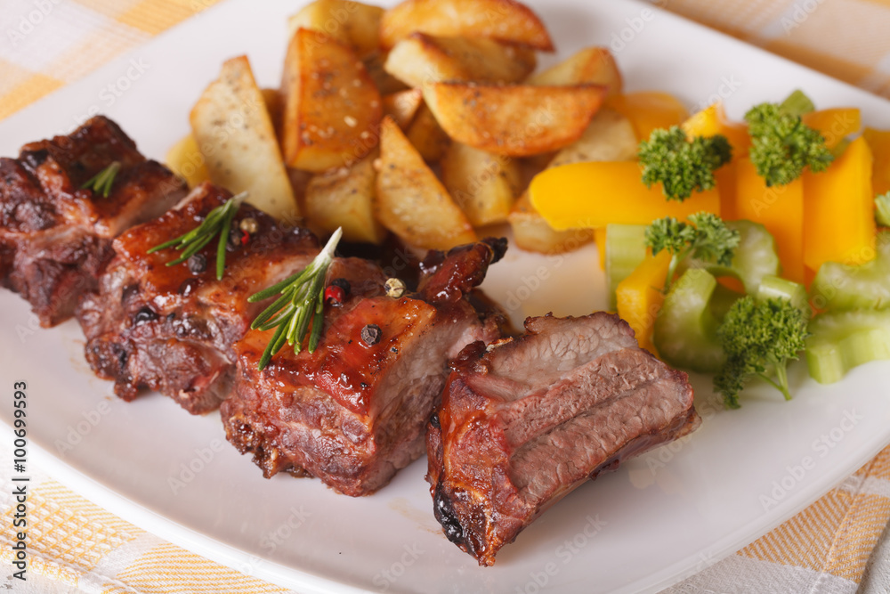 Delicious BBQ pork ribs with salad and potatoes close-up. horizontal
