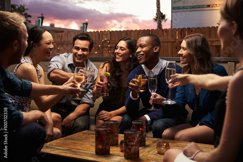 Photography Group Of Friends Enjoying Night Out At Rooftop Bar