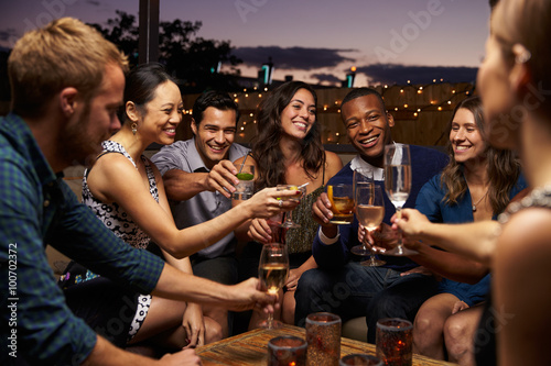 Photo Group Of Friends Enjoying Night Out At Rooftop Bar