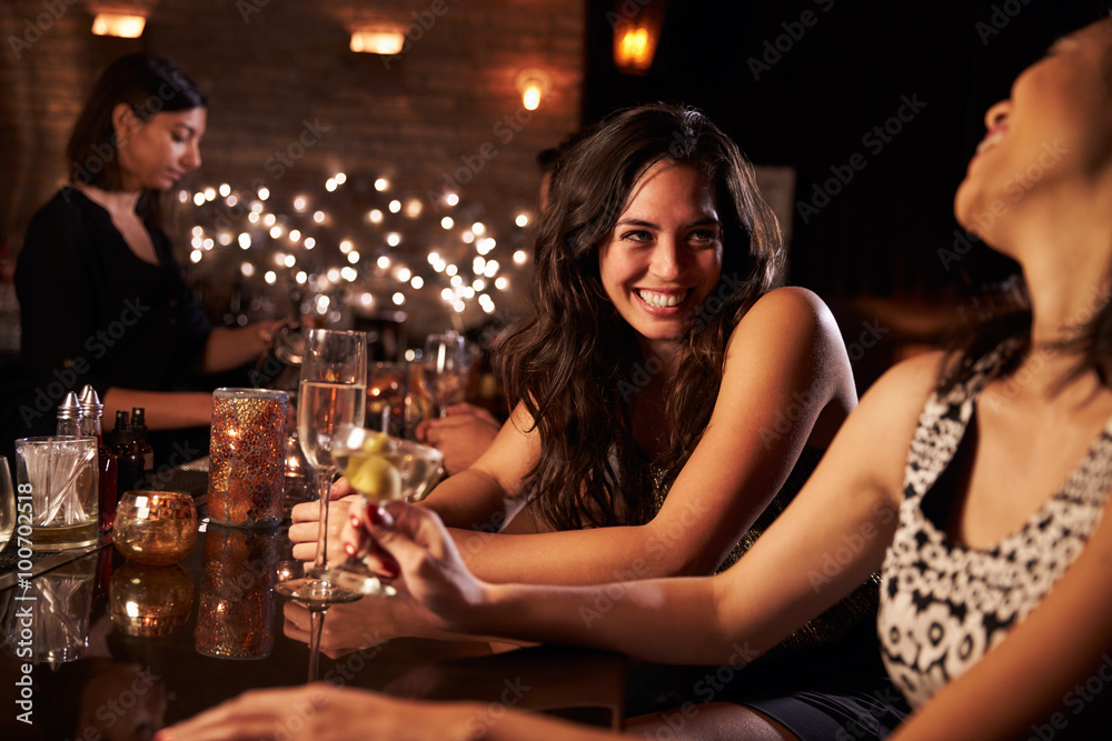 Female Friends Enjoying Night Out At Cocktail Bar