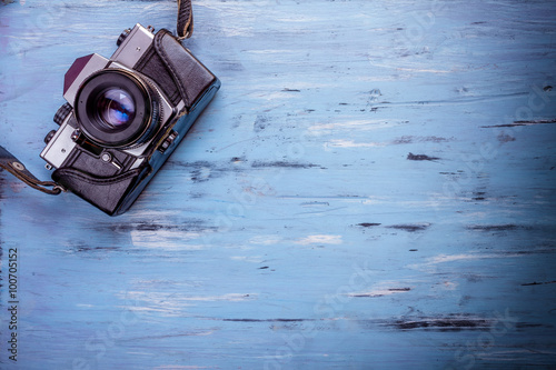 Old retro camera on wooden table background