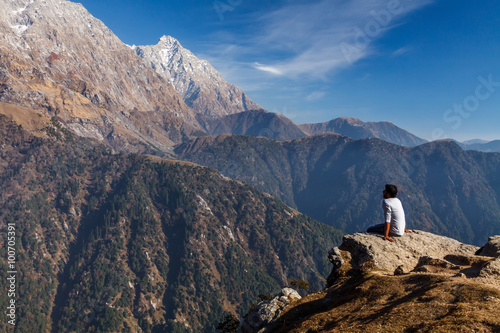 A man is looking at the mountains photo