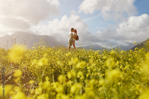 Romantic young couple embracing and kissing on summer day