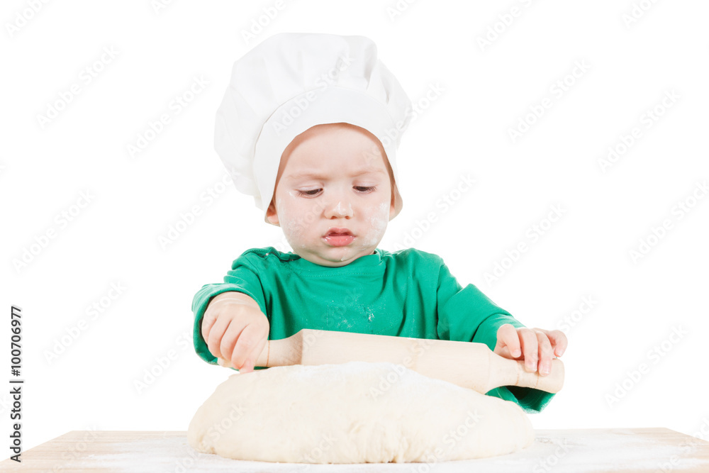 Serious little boy kneading dough for the cookies, isolated on white Serious little boy kneading dough for the cookies, isolated on white