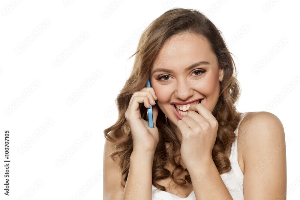 smiling young shy woman talks on the phone smiling young shy woman talks on the phone