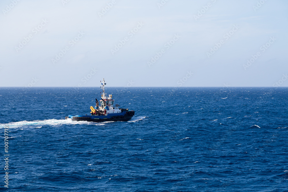 Blue Tugboat Heading Out Over Blue Sea