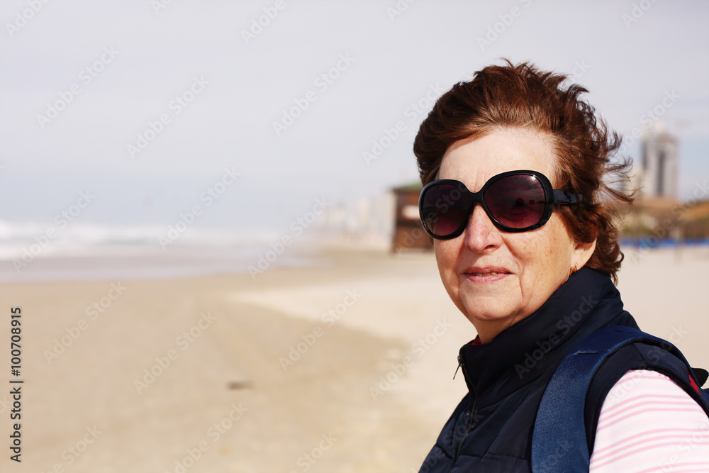 Senior woman standing on the winter beach