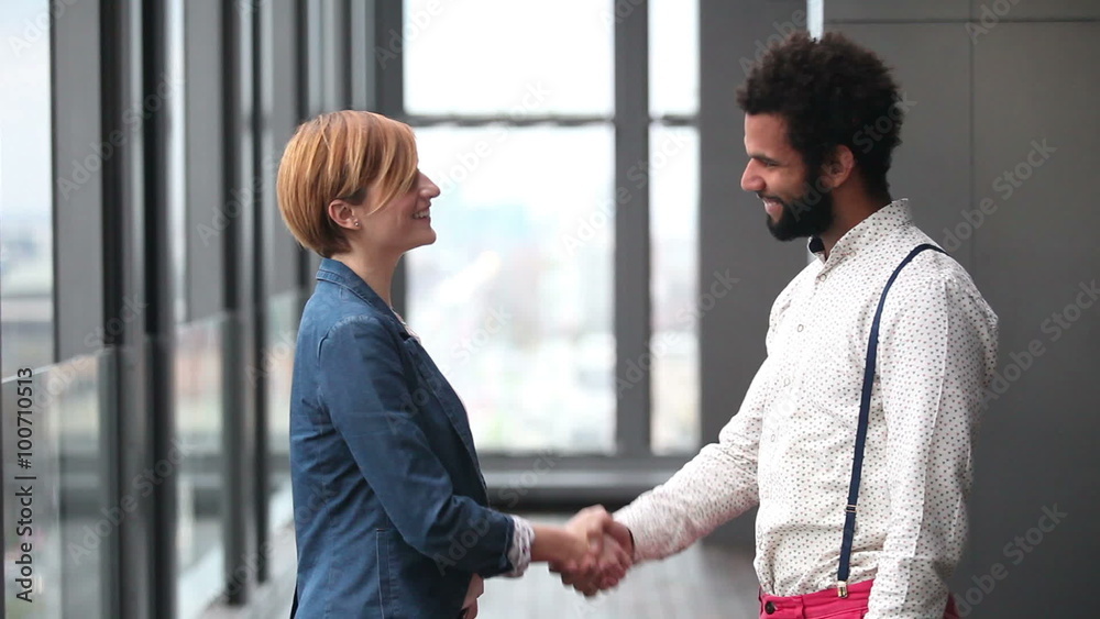Profile of female creative director and male advertising executive shaking hands Profile of female creative director and male advertising executive shaking hands