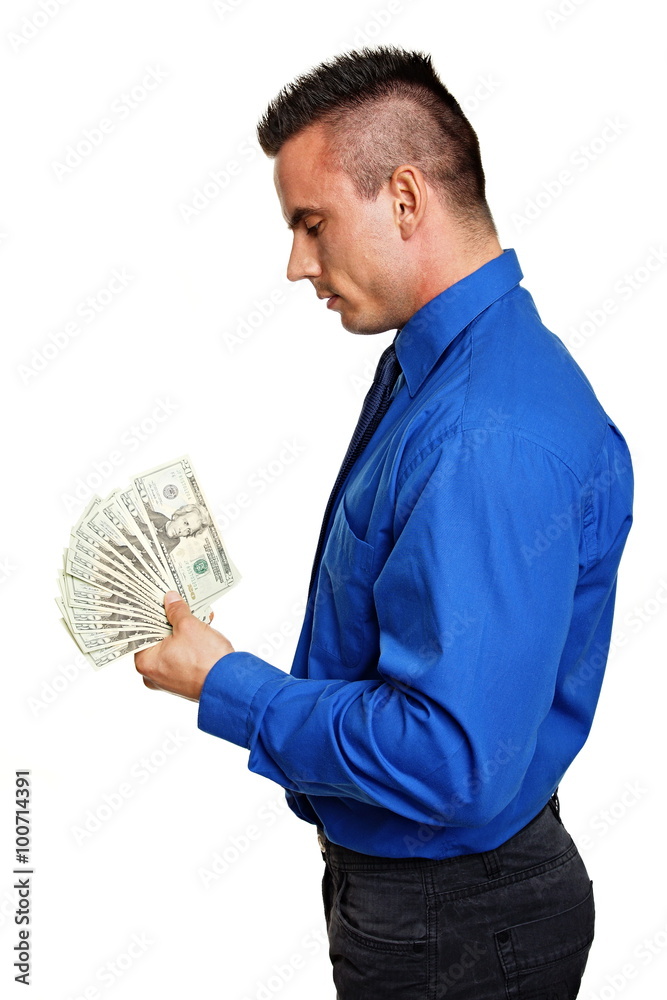 Profile of standing man in blue shirt holding in hand some paper money Profile of standing man in blue shirt holding in hand some paper money