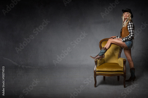 fashion cow girl with foot on armchair