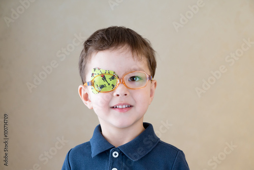 Little boy with okluder on the eye. photo