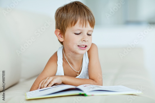 Tableau sur toile School boy are reading the book at home