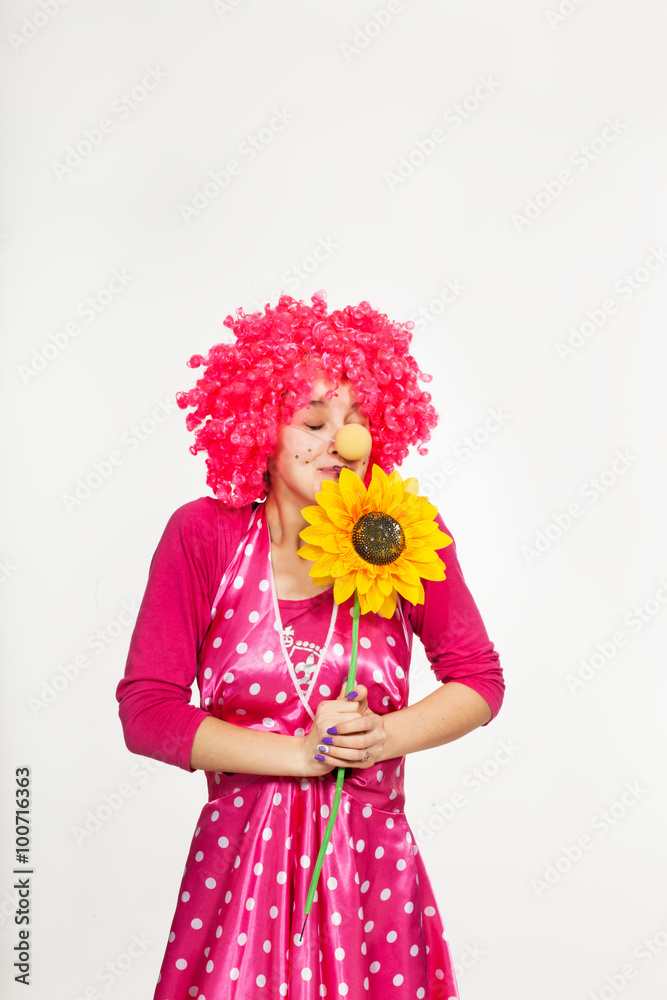 Cheerful, emotional clown in pink wig with yellow flower Cheerful, emotional clown in pink wig with yellow flower