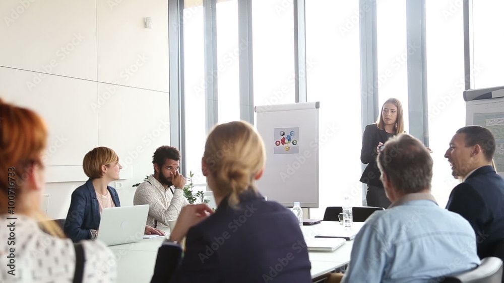 Beautiful businesswoman giving presentation to colleagues Beautiful businesswoman giving presentation to colleagues