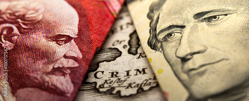 An antique map showing Crimea (Crim) in between a close-up of a Russian ruble banknote (figuring Lenin) and a 10 dollar banknote figuring Alexander Hamilton photo