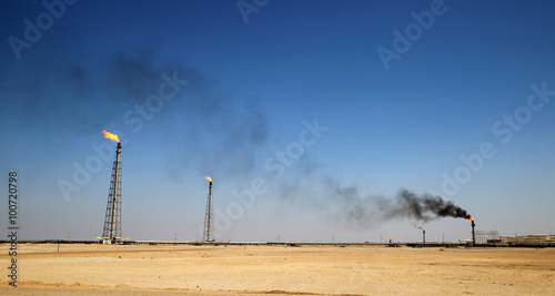 Photography A flare stack burning off excess gas at an oil refinery in the desert of the Mid