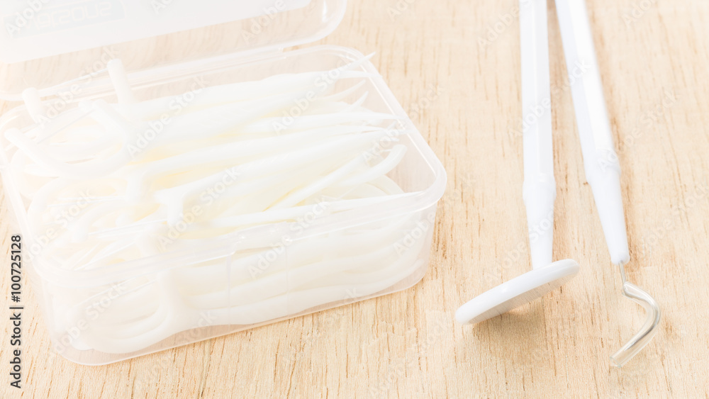 Oral Device : A box of white dental floss on wooden background Oral Device : A box of white dental floss on wooden background