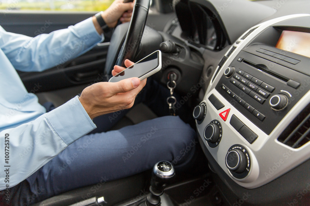 close up of man with smartphone driving car