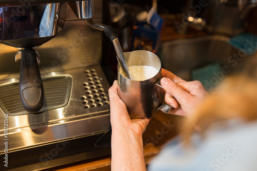 close up of woman making coffee by machine at cafe