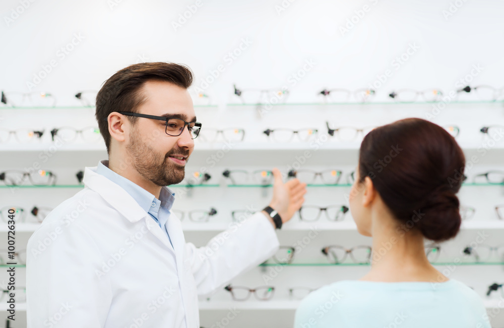 Fototapeta premium woman and optician showing glasses at optics store