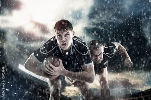 Canvas Print Rugby sportsmens, players run on a stadium
