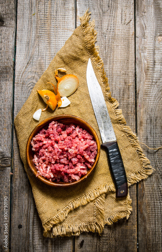 Fototapeta Naklejka Na Ścianę i Meble -  Raw ground beef with a butcher knife and a onion.