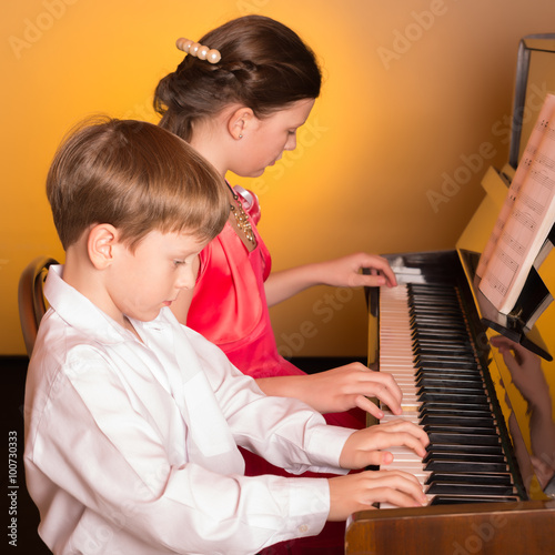 Brother And Sister Playing Piano. Piano player.