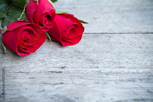 Red roses on woonden background. Valentine's day background.