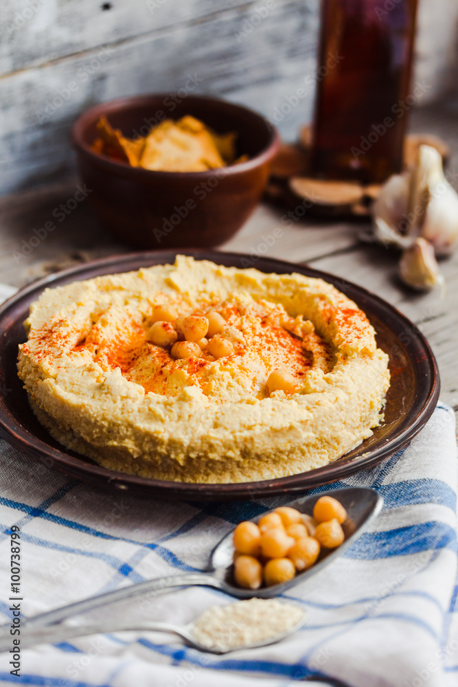 hummus of chickpeas, tahini paste and with paprika in a clay pla hummus of chickpeas, tahini paste and with paprika in a clay pla