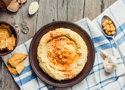 A bowl of creamy hummus with olive oil,garlic, paprika and pita
