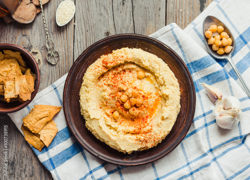 hummus of chickpeas, tahini paste and with paprika,rustic backgr