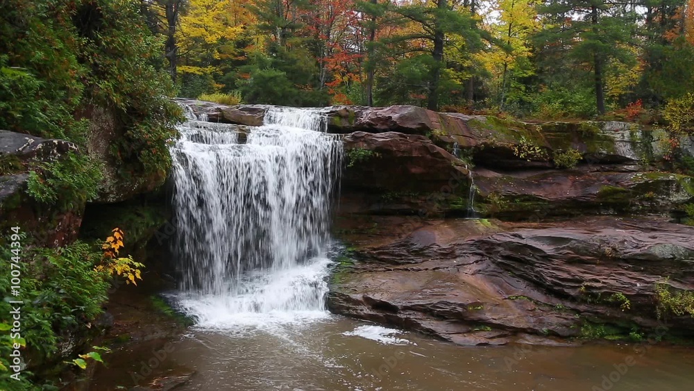 Whitewater tumbles over O Kun De Kun Falls, a beautiful remote waterfall in Michigan's western Upper Peninsula, in an autumn landscape.