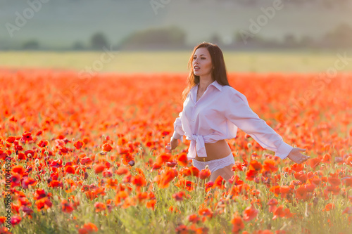 Girl at blooming poppy field