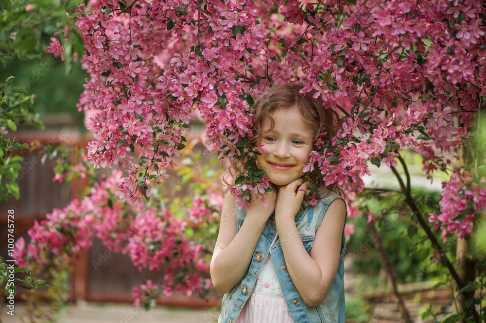 happy child girl in dress playing near blooming tree in spring garden. Rural cozy scene, outdoor seasonal activities. happy child girl in dress playing near blooming tree in spring garden. Rural cozy scene, outdoor seasonal activities.