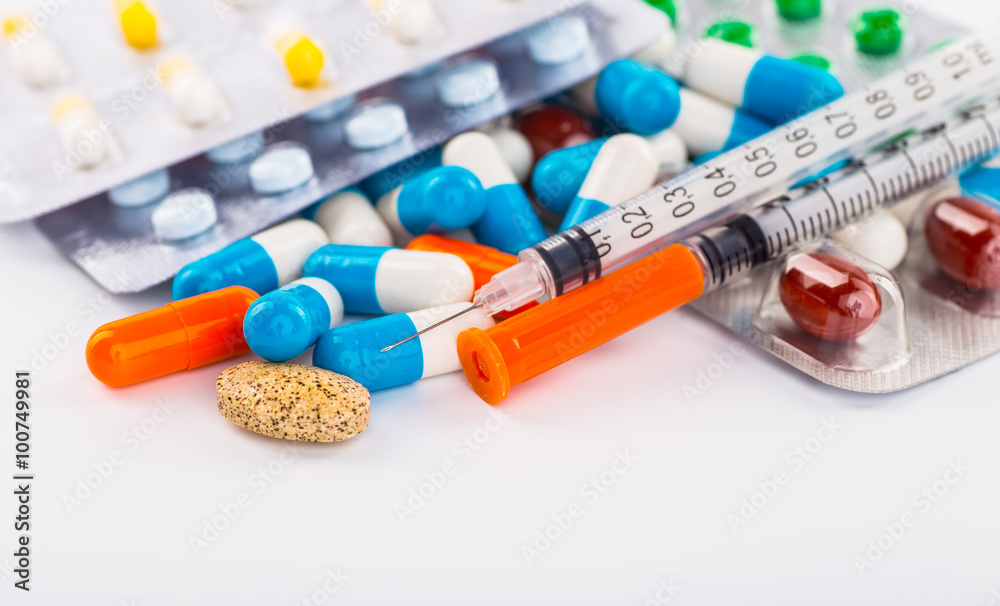 Various cold prescription bottles and a syringe isolated on a wh Various cold prescription bottles and a syringe isolated on a wh