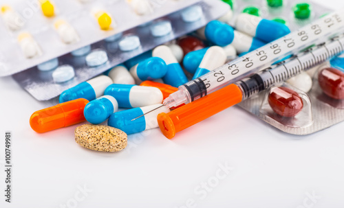 Various cold prescription bottles and a syringe isolated on a wh