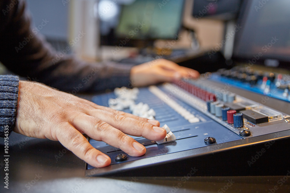 Hands of a man on adjusting a production console