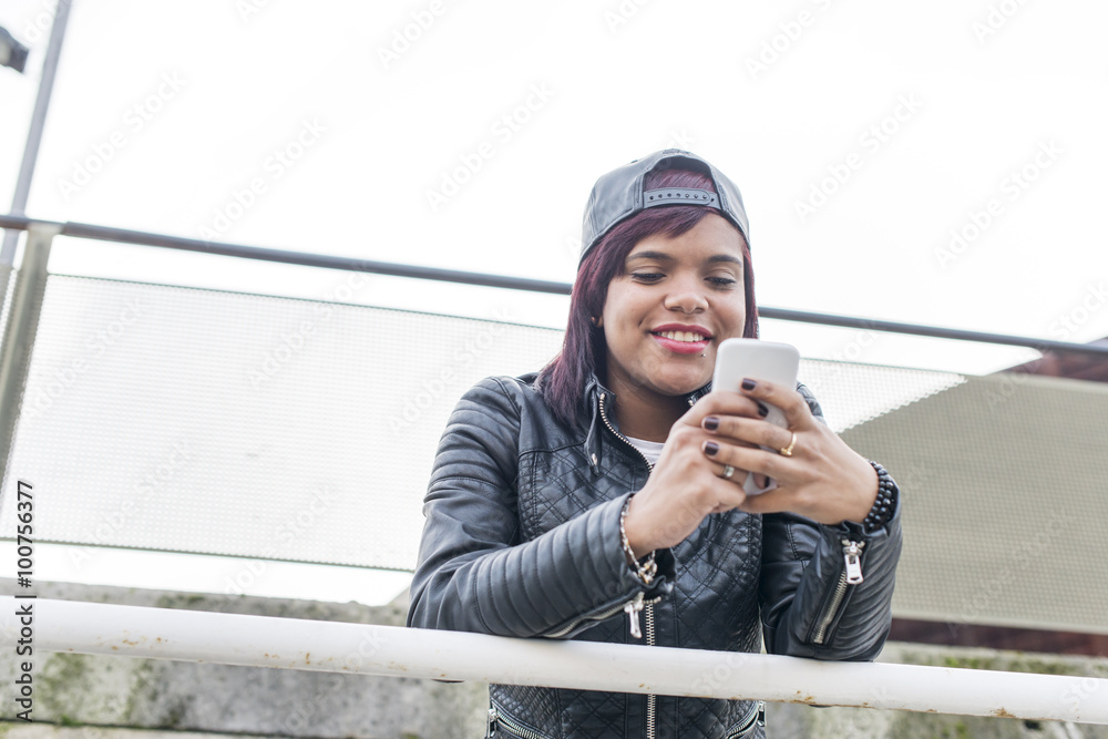 Obraz premium Fasion smiling woman using smart phone.