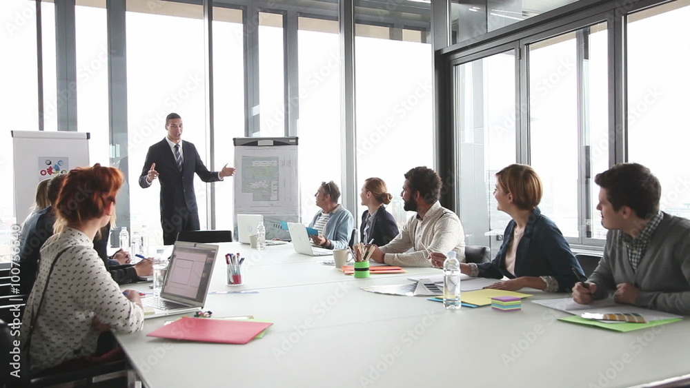Young director giving presentation to colleagues in conference room Young director giving presentation to colleagues in conference room