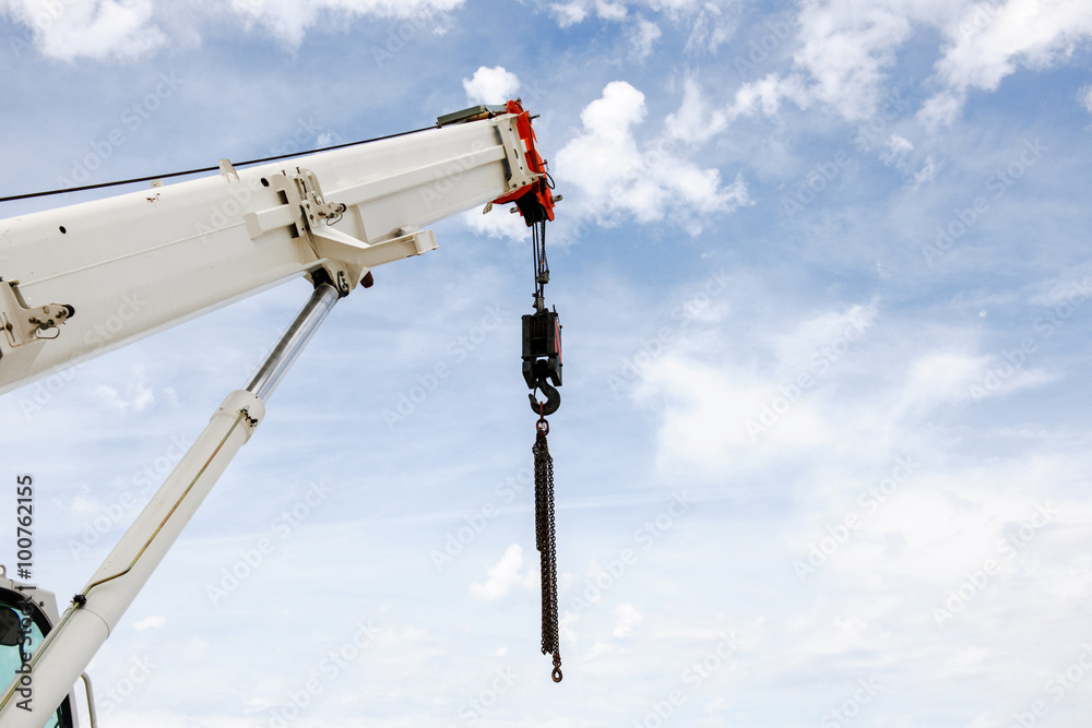 Powerful industrial crane against blue sky with few clouds Powerful industrial crane against blue sky with few clouds