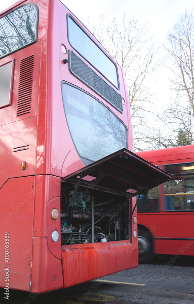 Damaged red public bus with open bonnet