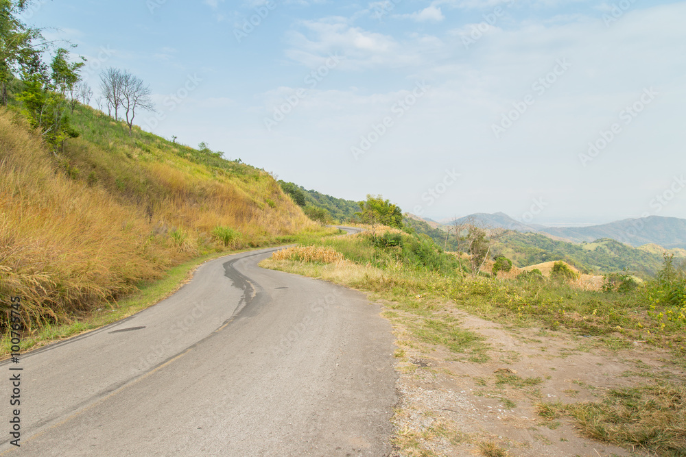 road to moutains with clouds in blue sky