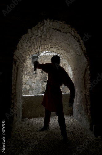silhouette of medieval warrior attacking by a sword