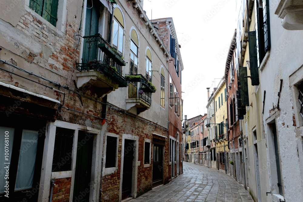 Empty Venetian street curves away from camera