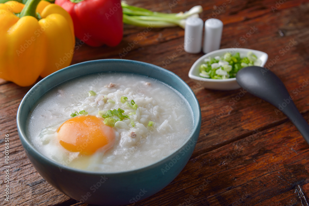 Thai chinese asian rice porridge with pork and egg in bowl, co Thai chinese asian rice porridge with pork and egg in bowl, co