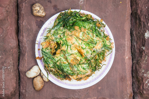 Thai Cuisine; cha-om omelet in white plate