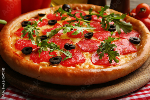 Tasty pizza with salami on decorated wooden table, close up