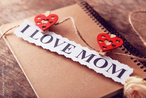 Notebook for mother's day and flowers on wooden background